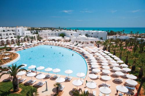 an overhead view of a swimming pool with umbrellas and chairs at Club Palm Azur Families and Couples in Midoun