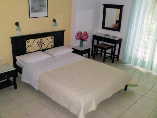 a bedroom with a large bed and a table at Sundy's Studios in Nydri