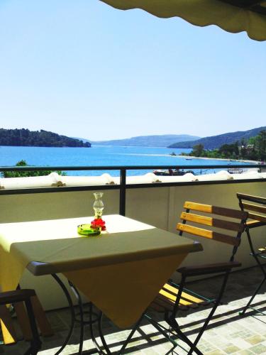a table and chairs on a balcony with a view of the water at Sundy's Studios in Nydri