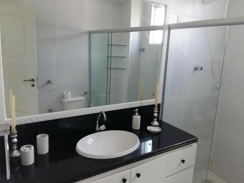 a bathroom with a sink and a glass shower at Habana Beach Flat in Natal