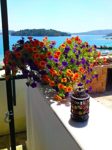 a bunch of flowers sitting on a ledge at Sundy's Studios in Nydri