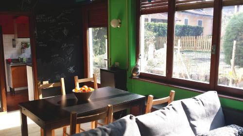 ein Esszimmer mit einem Tisch und einer grünen Wand in der Unterkunft Casa Muffin 3 in Cannobio