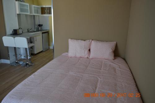 ベナルマデナにあるHercules Apartmentのベッドルーム1室(ピンクの枕が付いた大型ベッド1台付)