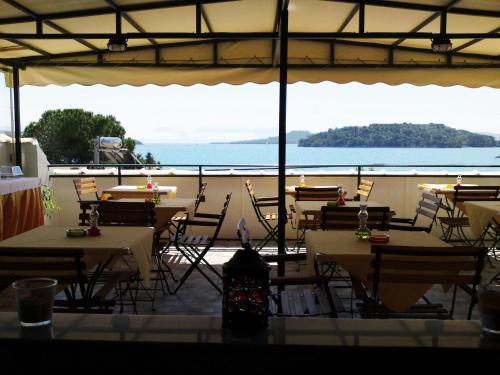 a restaurant with tables and chairs and a view of the ocean at Sundy's Studios in Nydri