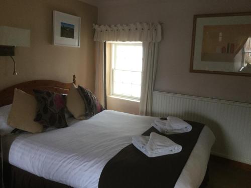 a bedroom with a bed with towels on it at The Golf Hotel in Crail
