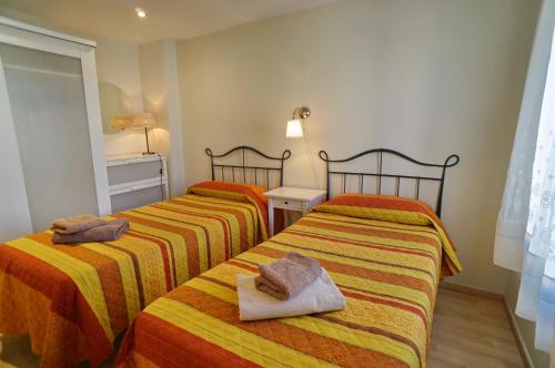 two beds in a room with two towels on them at Barcelona4Seasons - Gavina in Barcelona