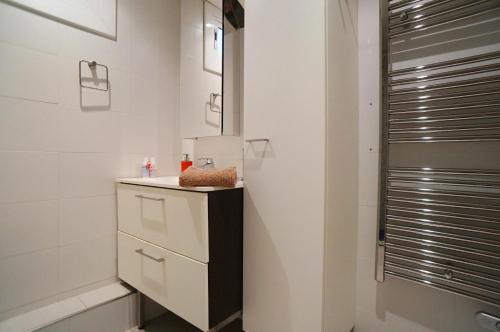a white bathroom with a sink and a mirror at Barcelona4Seasons - Gavina in Barcelona