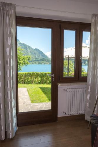a sliding glass door with a view of the water at Serena Charme Garden in Ledro