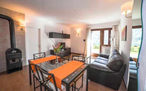 a living room with a table and a couch and a stove at Serena Charme Garden in Ledro