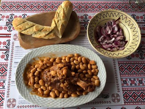 a table with a plate of food and a bowl of beans at Hanu lu Mos Opinca in Deva
