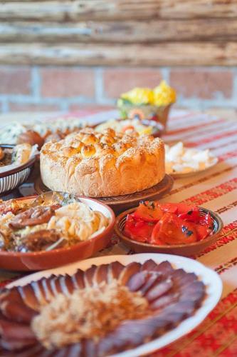 a table topped with different types of food on plates at Guest House Golijski Dar in Dajići