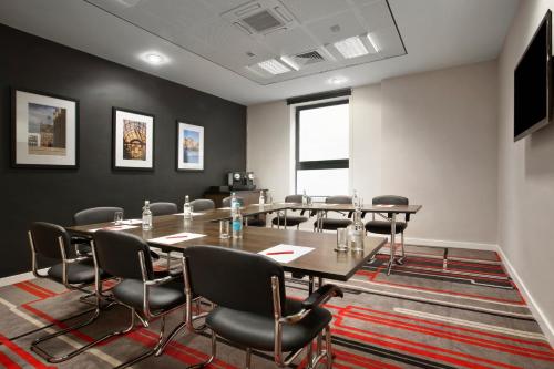 a conference room with a long table and chairs at Ramada Encore Newcastle-Gateshead in Newcastle upon Tyne