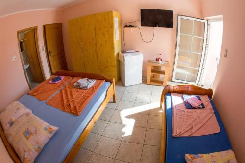 a bedroom with two beds and a refrigerator at Guest House Almond in Becici