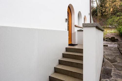 a stairway leading to a white building with a yellow door at Fribauhaus in Fribourg