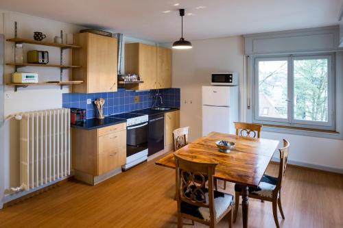 uma cozinha com uma mesa de madeira e uma sala de jantar em Fribauhaus em Fribourg