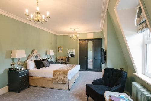 a bedroom with a bed and a chair at The Spa Hotel in Royal Tunbridge Wells