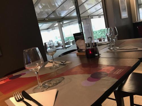 a table with wine glasses on top of it at Campanile Colmar - Parc des Expositions in Colmar