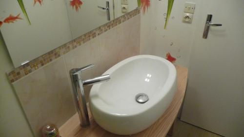 a white sink in a bathroom with a mirror at le Vercors en toute simplicite in Autrans