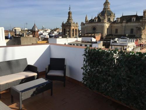 a large building with a clock on the top of it at Apartamentos Cuna 41 in Seville
