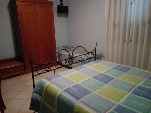a bedroom with a bed with a colorful blanket at Hotel Ponte San Vittorino in Assisi