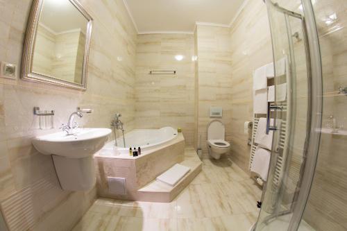 a bathroom with a sink and a tub and a toilet at Hotel Viliam Frano in Nitra