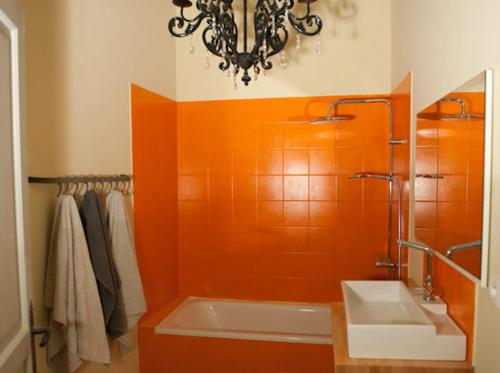 a bathroom with a tub and a sink and a chandelier at Appartement La Masse in Avignon