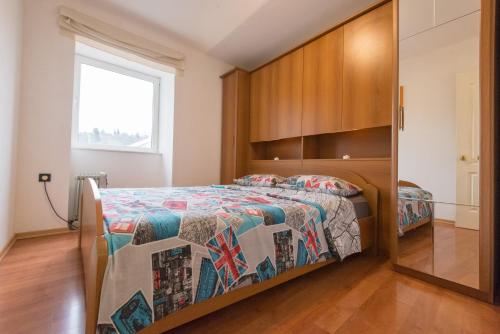 a bedroom with a bed and a large window at Apartment Roberta in Rijeka