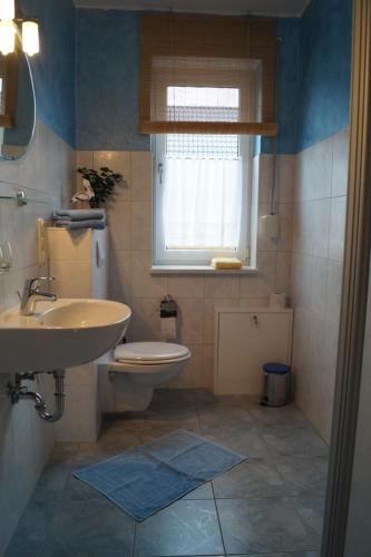 a bathroom with a sink and a toilet and a window at Ferienhaus Käpt´n Moritz in Karlshagen