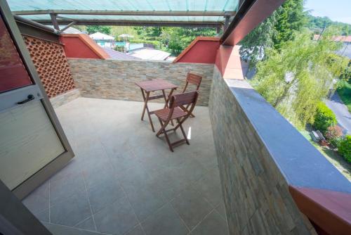a patio with two chairs and a table on a balcony at Cuccaro Club - Val di Vara e Cinque Terre in Rocchetta di Vara
