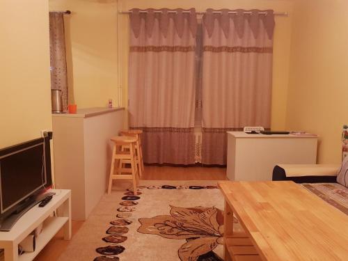 a living room with a television and a table at Vast Mongolia Tour & Hostel in Ulaanbaatar
