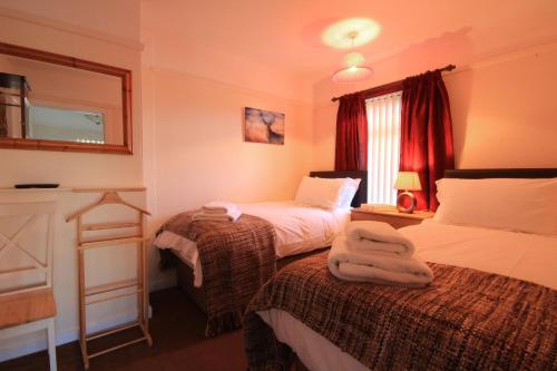 Habitación de hotel con 2 camas y ventana en Sheneval Apartment en Inverness