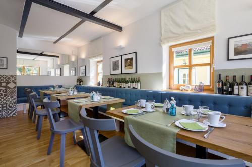 ein Restaurant mit Holztischen und -stühlen und Weinflaschen in der Unterkunft Weingut & Gästezimmer Edelmann in Göttlesbrunn