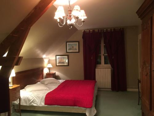 ein Schlafzimmer mit einem großen Bett mit einer roten Decke in der Unterkunft le petit clos in Baugé