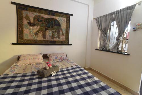 a bedroom with a bed and a picture on the wall at Cactus Guesthouse in Arambol