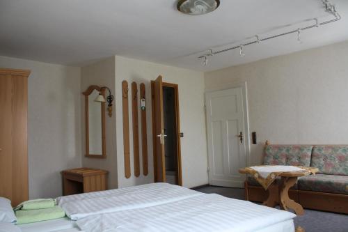 a bedroom with a bed and a couch at Hotel St. Hubertus in Wallmerod