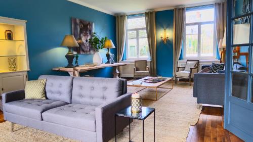 a living room with blue walls and a couch at La Régie de Franc-Warêt in Franc-Waret