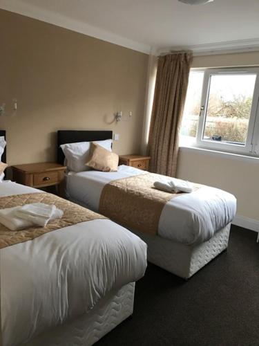 a hotel room with two beds and two lamps at The Waverley Inn in Dingwall