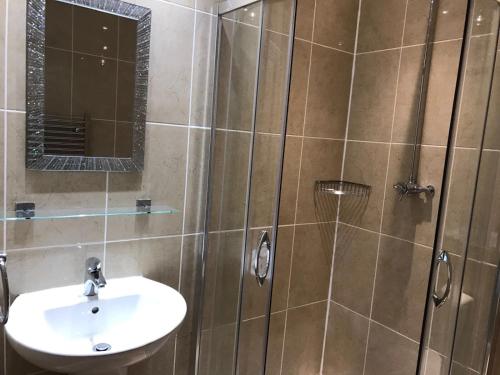 a bathroom with a sink and a shower with a mirror at The Waverley Inn in Dingwall