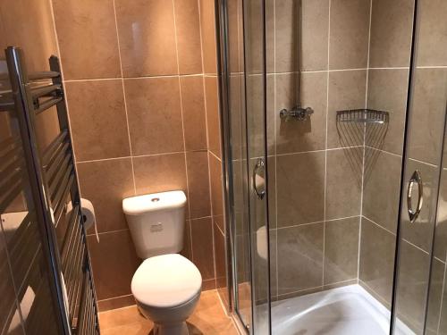 a bathroom with a toilet and a glass shower at The Waverley Inn in Dingwall