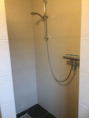 a shower with a hose in a bathroom at Bed en Breakfast Donkersvoort in Benk en Donk