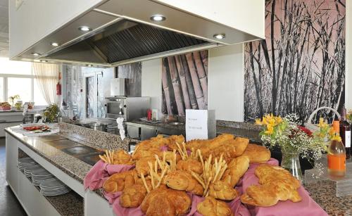 a bunch of breads and pastries on a counter in a kitchen at Hotel Salobreña Suites in Salobreña