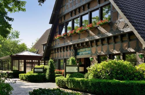 un edificio con flores a un lado. en Romantik Hotel Jagdhaus Eiden am See, en Bad Zwischenahn