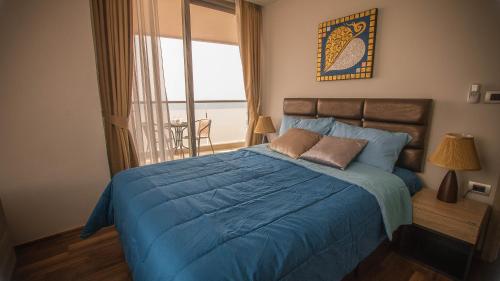 芭達雅南區的住宿－高塔公寓，一间卧室设有蓝色的床和窗户。