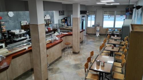 un restaurante con mesas y sillas y un bar en Hostal Athlanta, en Villalpando