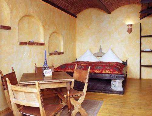 a bedroom with a bed and a table and chairs at Gästehaus Mezcalero in Dresden