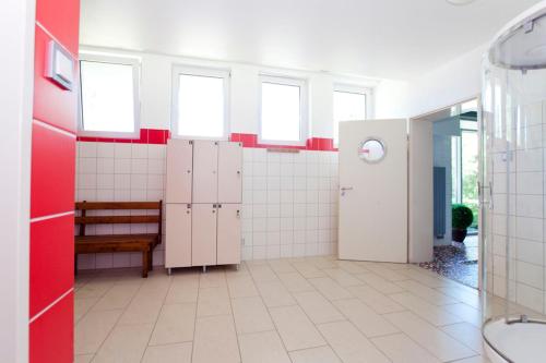 a bathroom with pink and white stalls and a bench at Hotel Ameliówka in Masłów