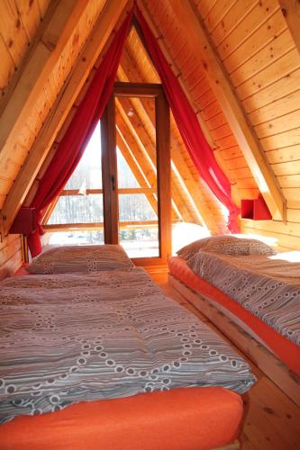 two beds in a room with a large window at Holiday Home Edi in Delnice