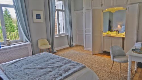 a bedroom with a bed and a sink and a mirror at La Régie de Franc-Warêt in Franc-Waret