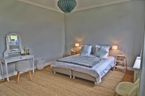 a bedroom with a bed and a desk and a mirror at La Régie de Franc-Warêt in Franc-Waret