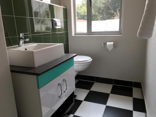 a bathroom with a sink and a toilet at HP Twelve Accommodation in Nelspruit